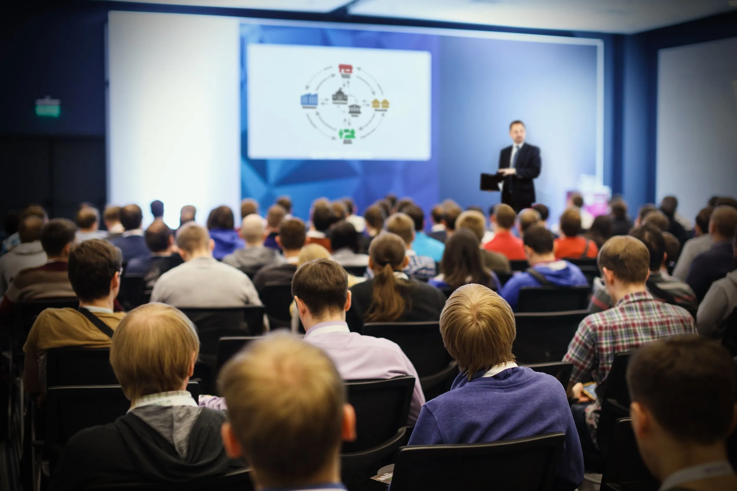 A speaker presenting to a full lecture hall
