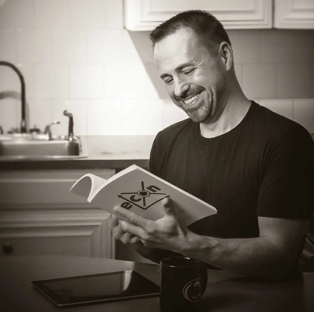 Frank Sorokach smiling while reading a book